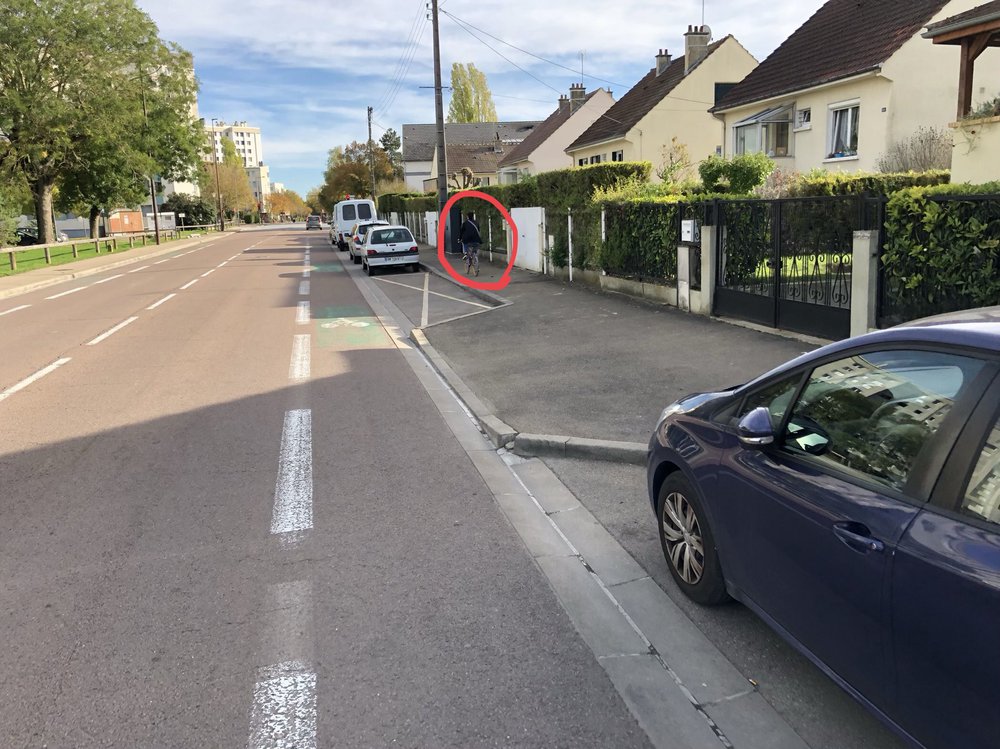 N'étant pas à l'aise sur la route malgré la bande cyclable, le cycliste est contraint de rouler sur le trottoir.
