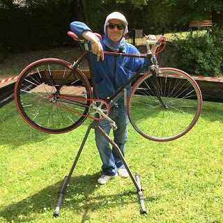Guillaume Courtieux devant le vélo qu'il a créé pour son fils à partir de vieux vélos.